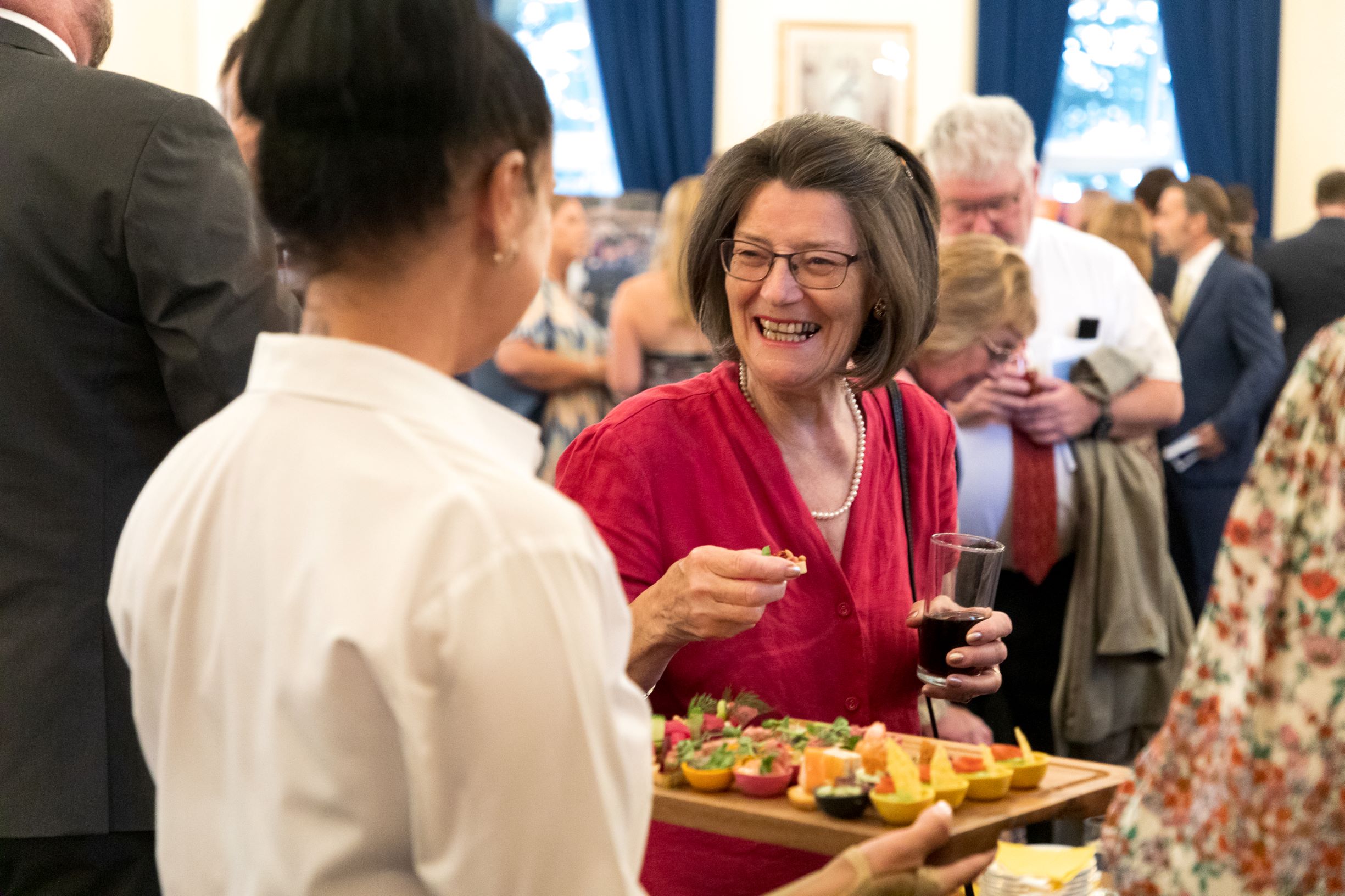 Image shows caterer holding plate of food for guests.